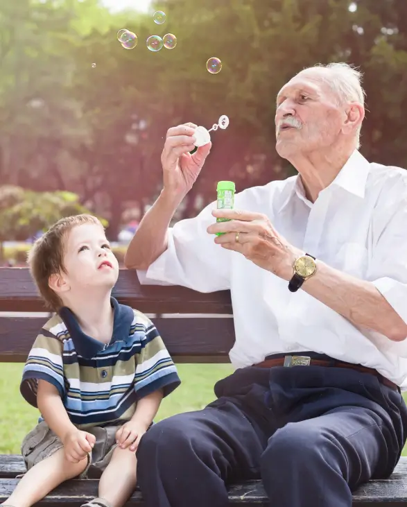 Grandfather blowing bubbles for his grandson