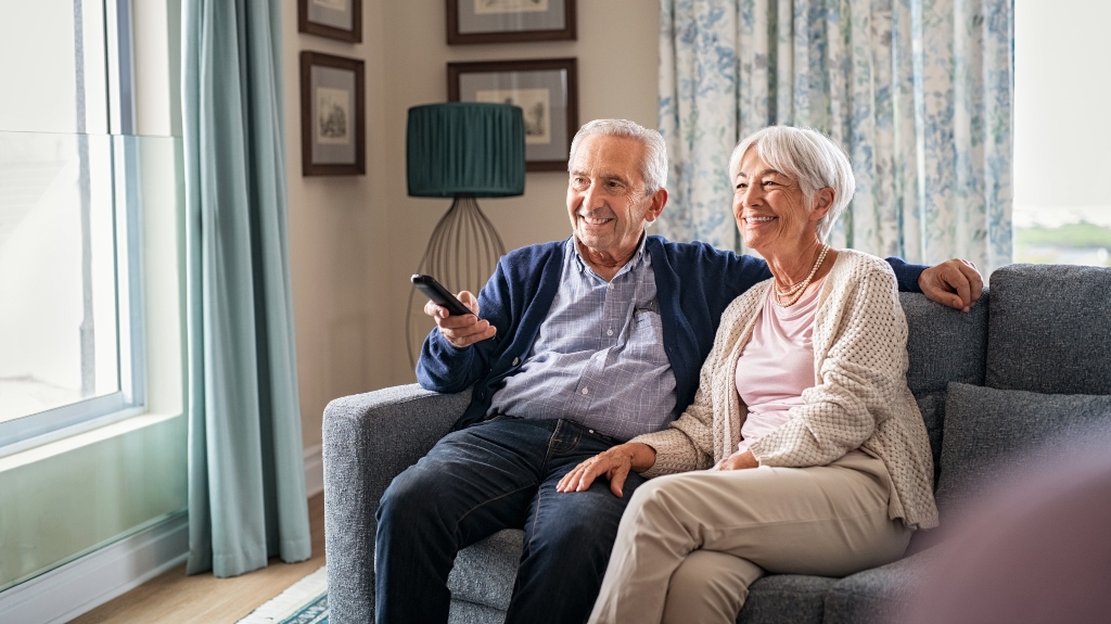 happy old couple sitting on a couch