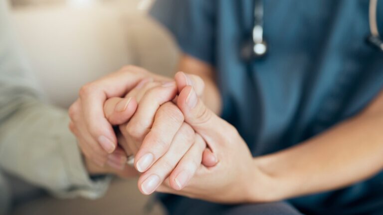 Nurse holding person's hand