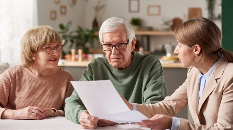 Senior couple discussing documents with real estate agent