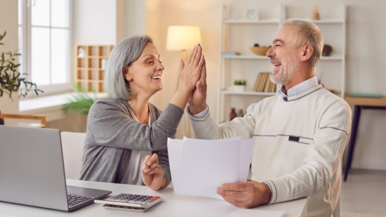 Two happy seniors smile at each other