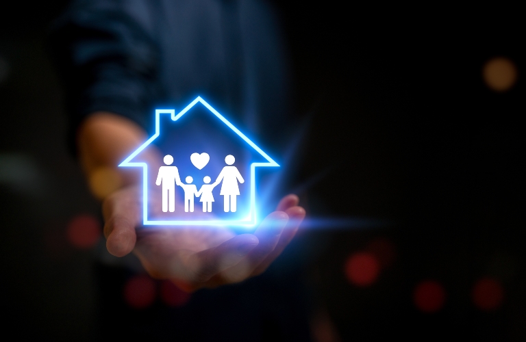 man holding glowing figurine of house and family on his hand