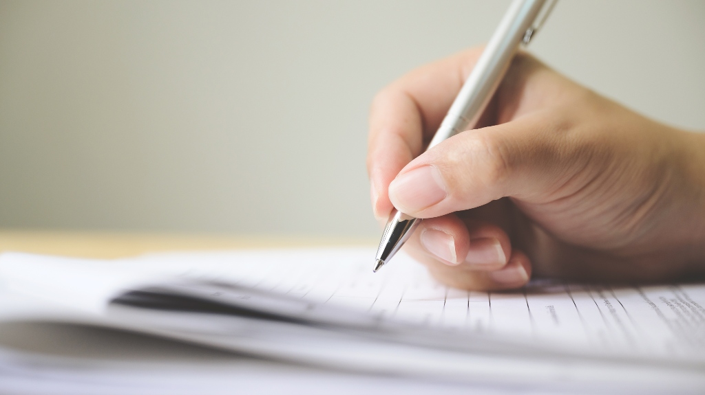 woman is signing documents
