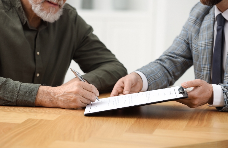 Notary showing senior man where to sign