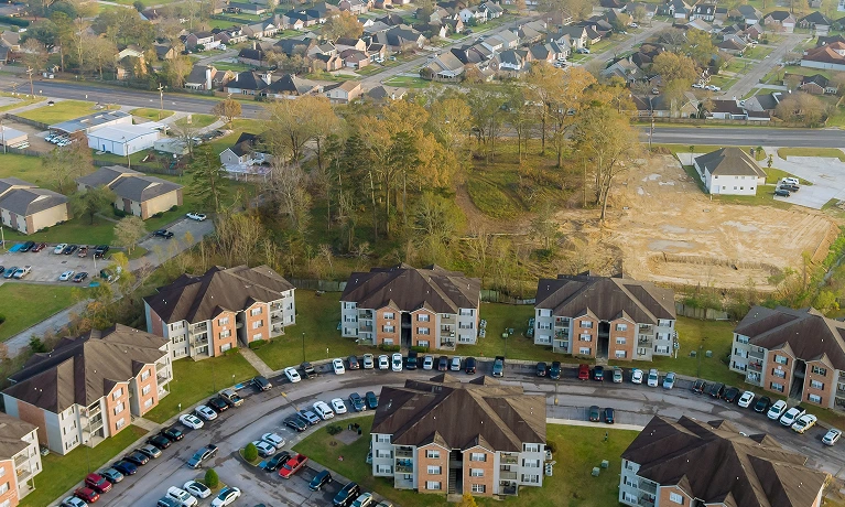 Aerial view of a suburban residential neighborhood featuring houses, streets, and green spaces