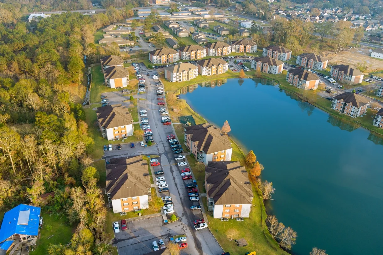 Aerial view showcasing a serene lake surrounded by a residential area with houses and greenery