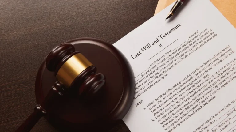 Wooden judge's gavel and pen resting on a Last Will and Testament document on brown surface.